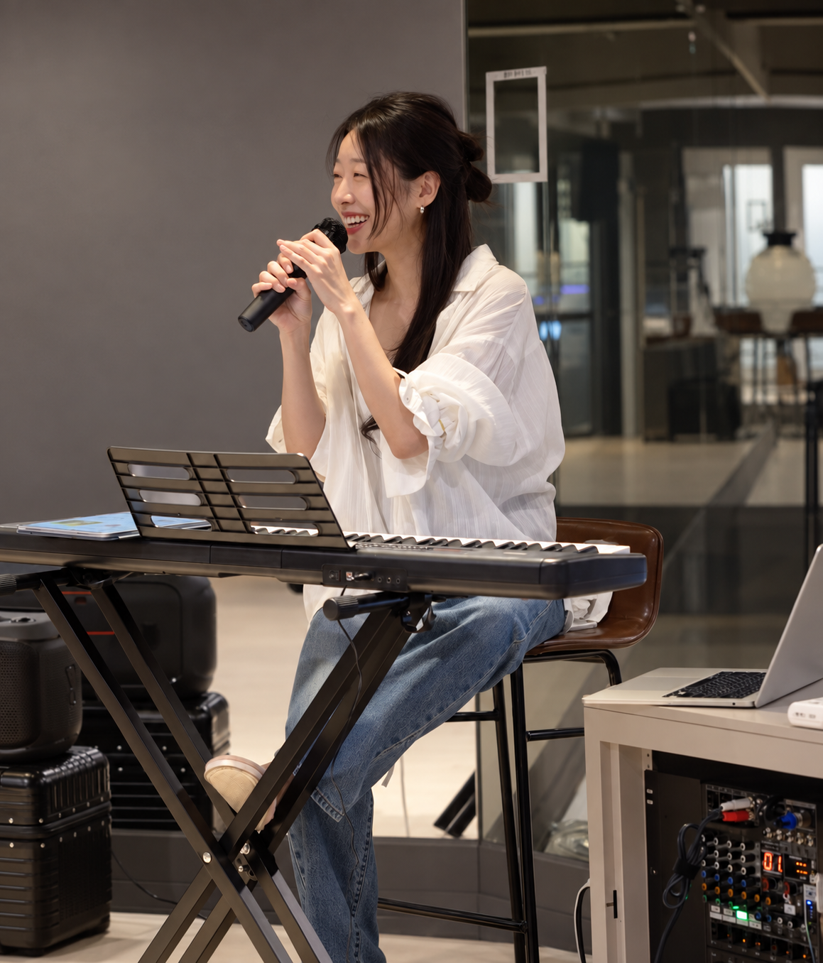 키보드 앞에서 마이크를 들고 웃는 김세라 디렉터