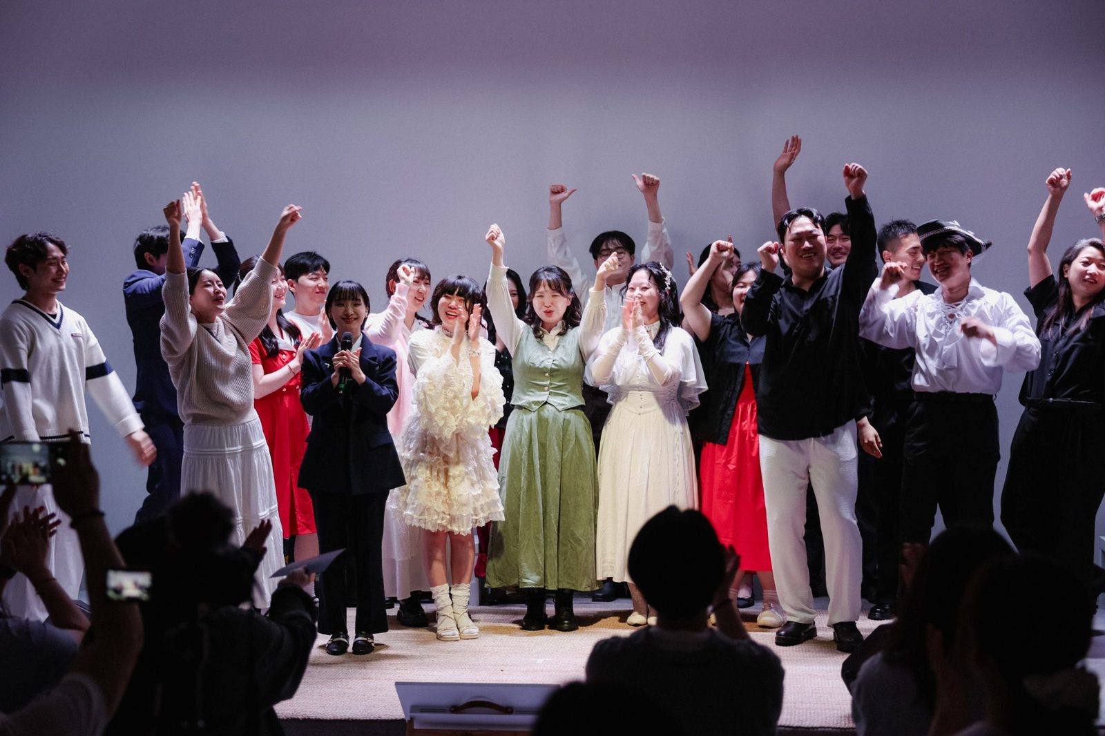 공연을 마친 WE STILL SING 단원들이 무대 위에서 두 손을 들고 환호하는 모습